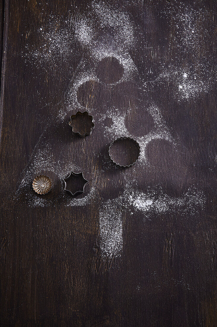 Christmas tree motif and vintage biscuit cutters on a dark wooden background