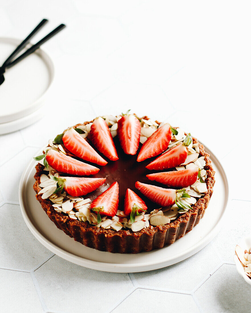Nougat tart with sliced almonds and strawberries