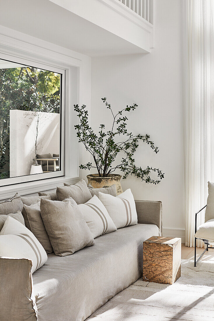 Modernes Wohnzimmer im Küstenstil mit Leinensofa in Taupe, Teppich und Beistelltisch aus Stein