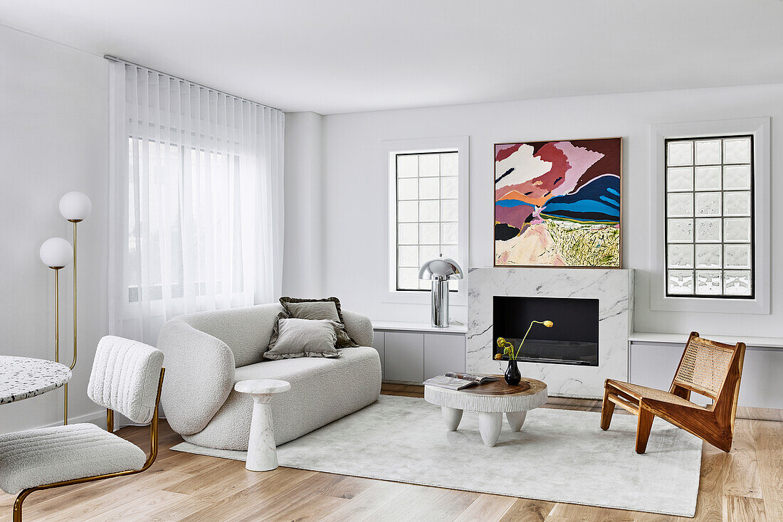 80s style living room with light bouclé sofa, coffee table, and replica designer chairs