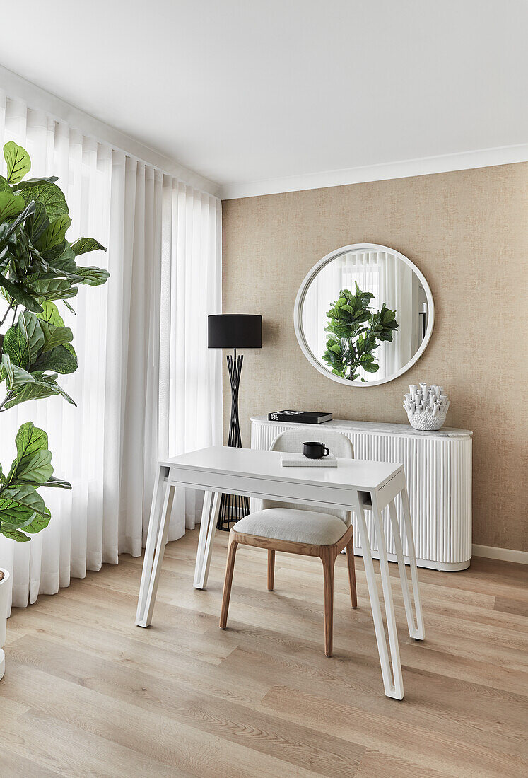 Modern Scandi-style home office with desk and chair, white 80s-style fluted console table and round mirror