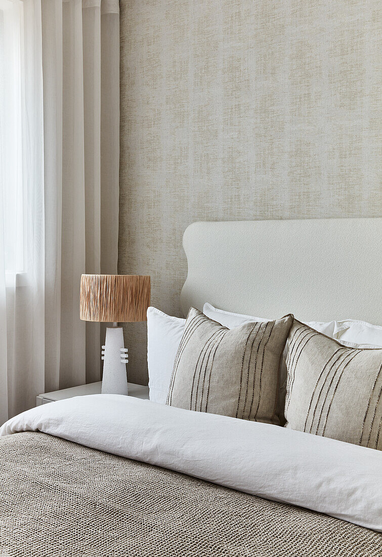 Bedroom in cream, 80s style wavy headboard and tweed wallpaper