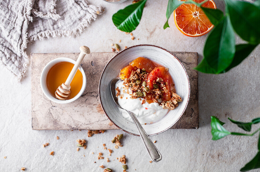 A yoghurt bowl with blood oranges, muesli and honey