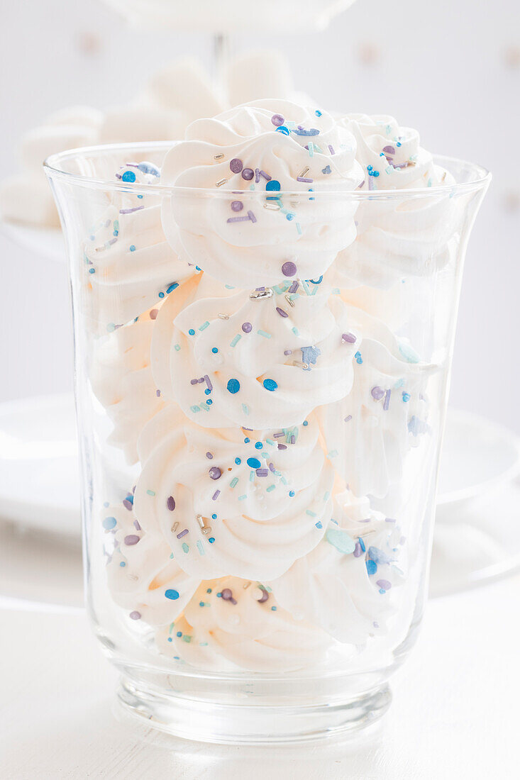 Meringues with blue sugar sprinkles in a jar