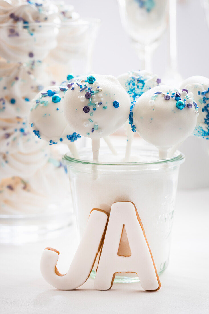 Weiße Cake Pops mit blauen Zuckerstreuseln