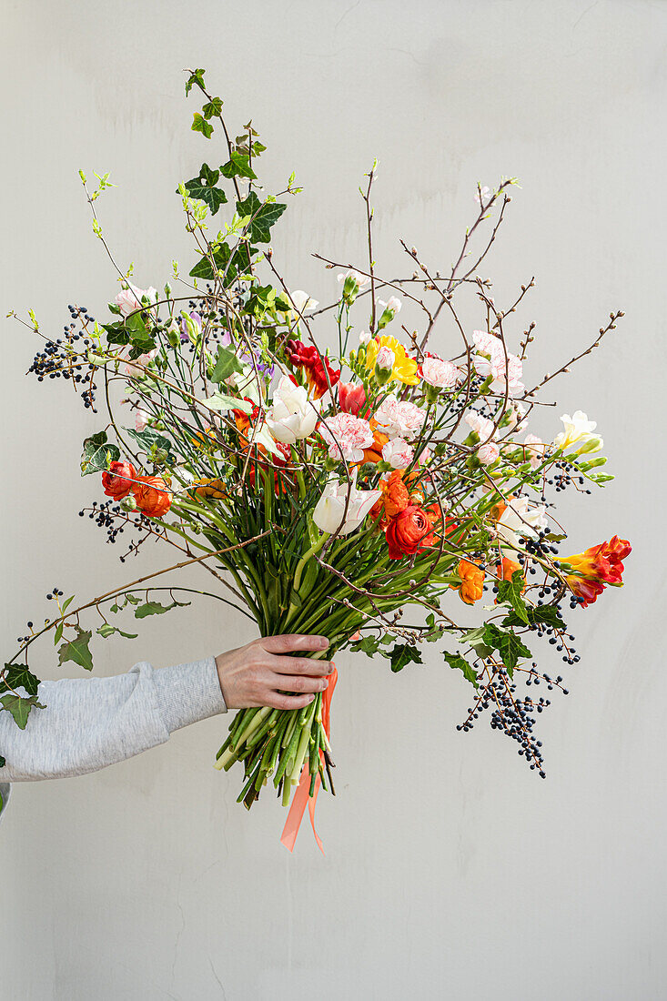 Hand holding colorful spring bouquet