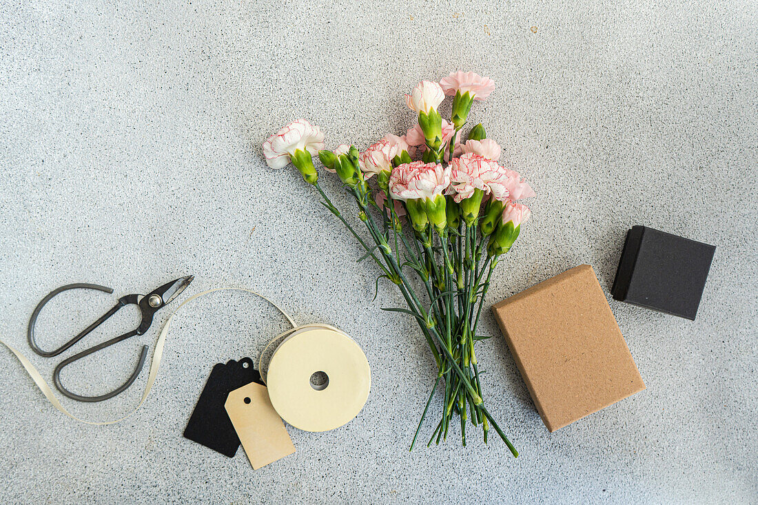 Nelken, Geschenkband, Papieranhänger und kleine Schachtel