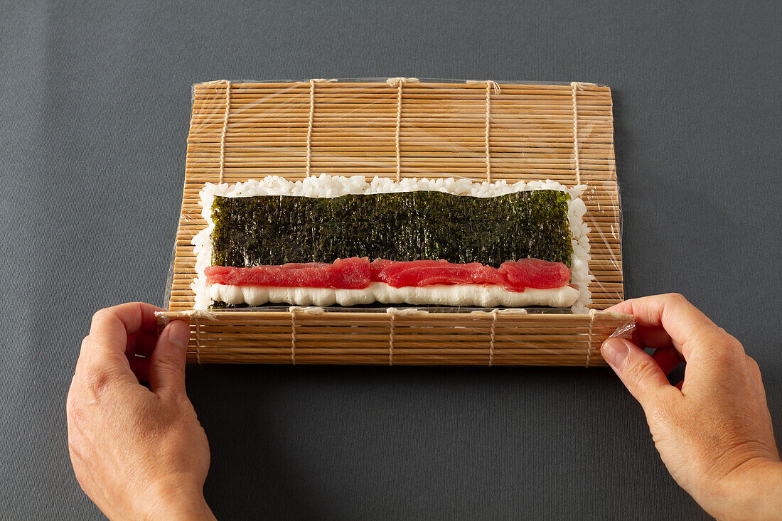 Making maki sushi with salmon