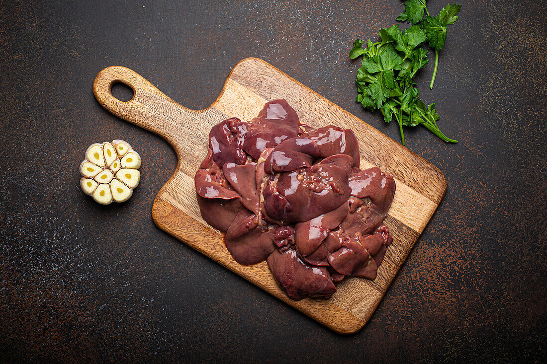 Raw chicken liver on a wooden cutting board