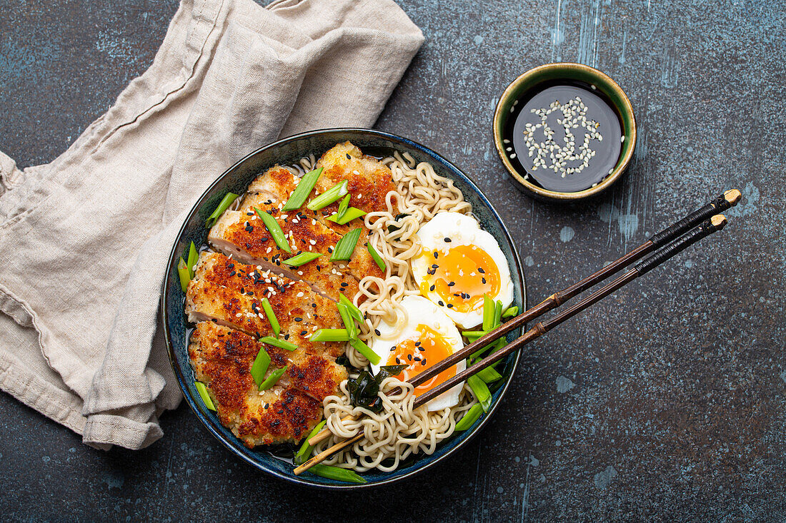 Asian noodles ramen soup with deep fried panko chicken fillet and boiled eggs