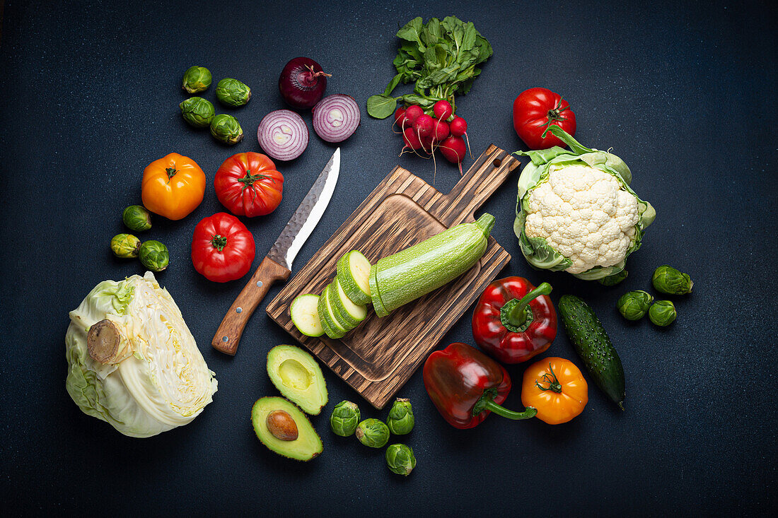 Fresh vegetables with a courgette on a wooden chopping board
