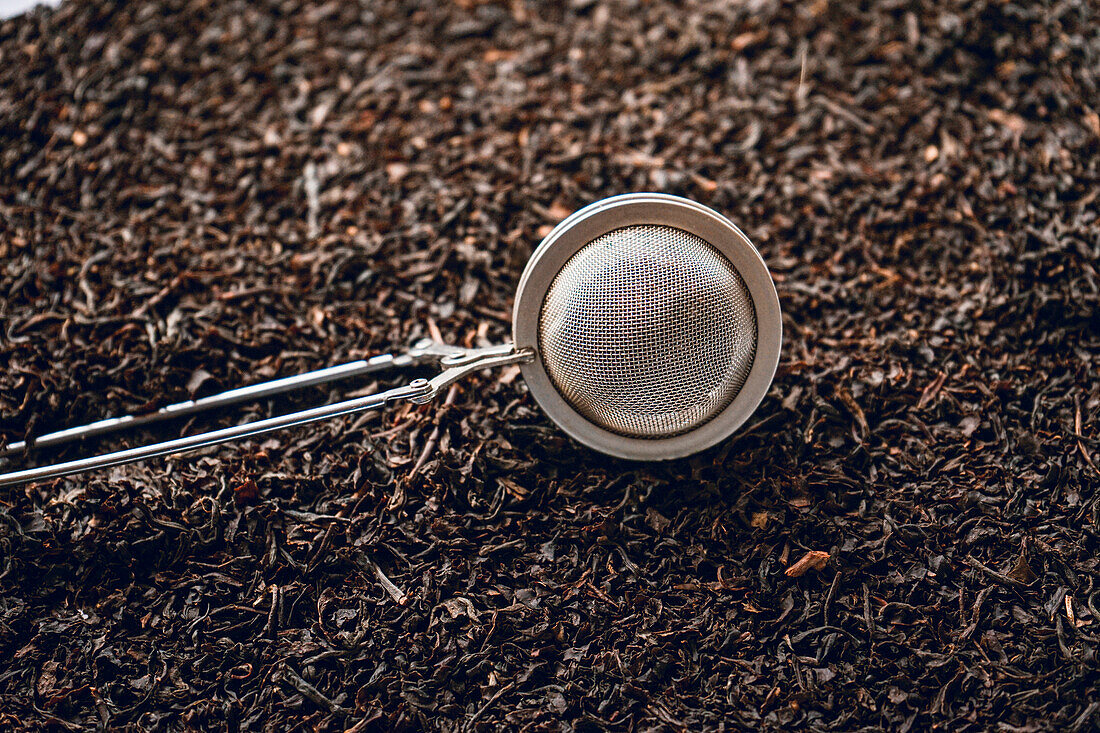 Metal tea strainer on black tea