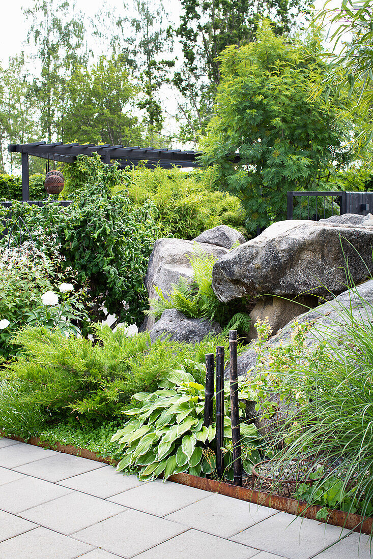 Garten mit großen Steinen und vielfältiger Bepflanzung