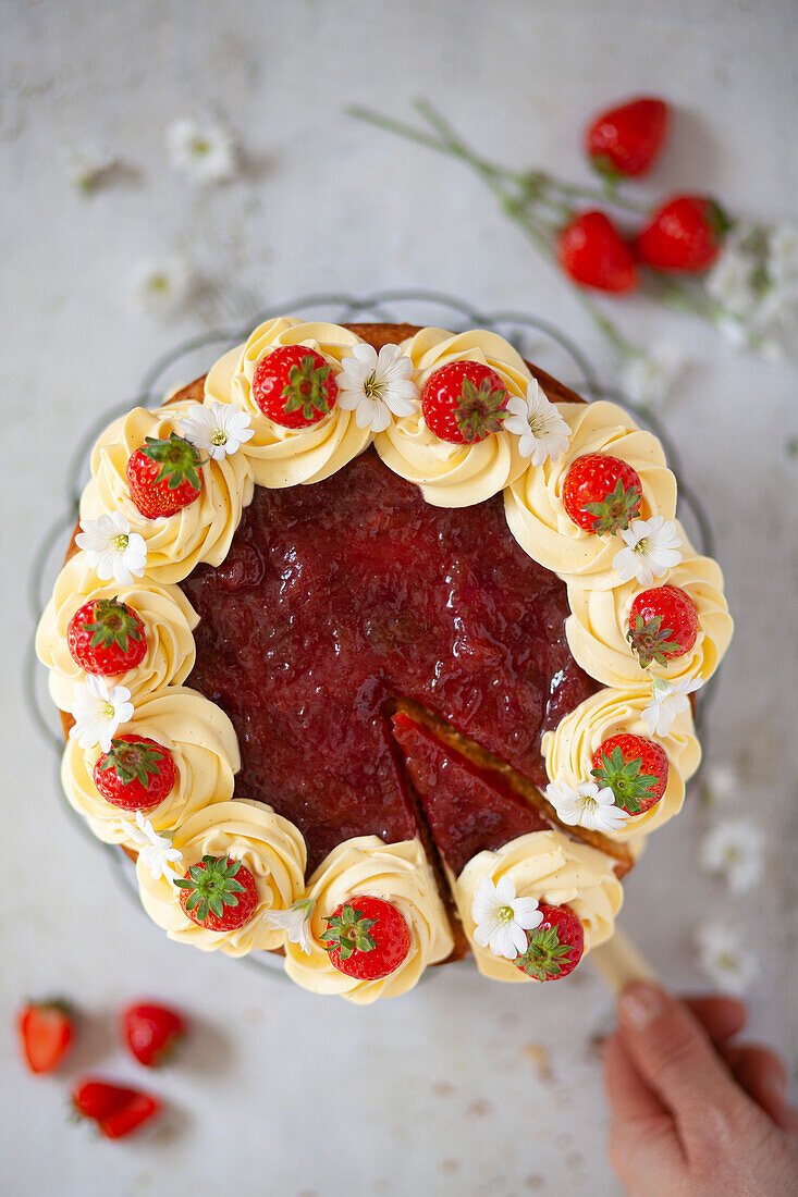 Cream cake with jam, strawberries, and flowers