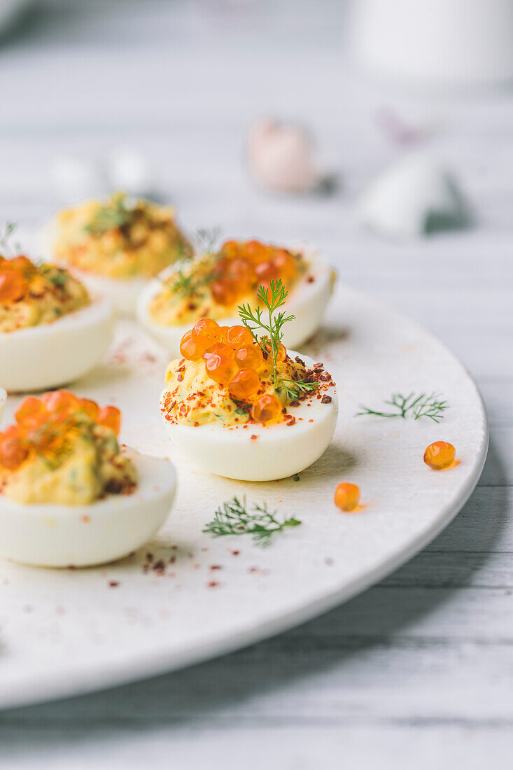 Deviled eggs with salmon caviar and herb garnish
