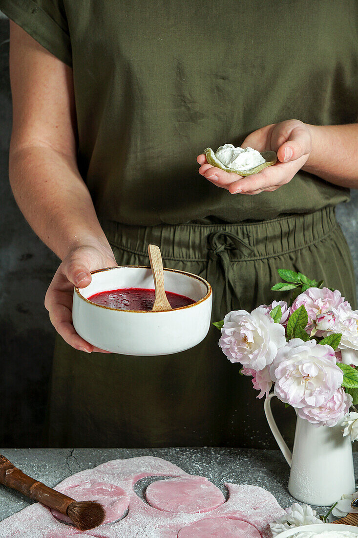 Preparing mochi (Japanese dessert) with matcha powder and cherries