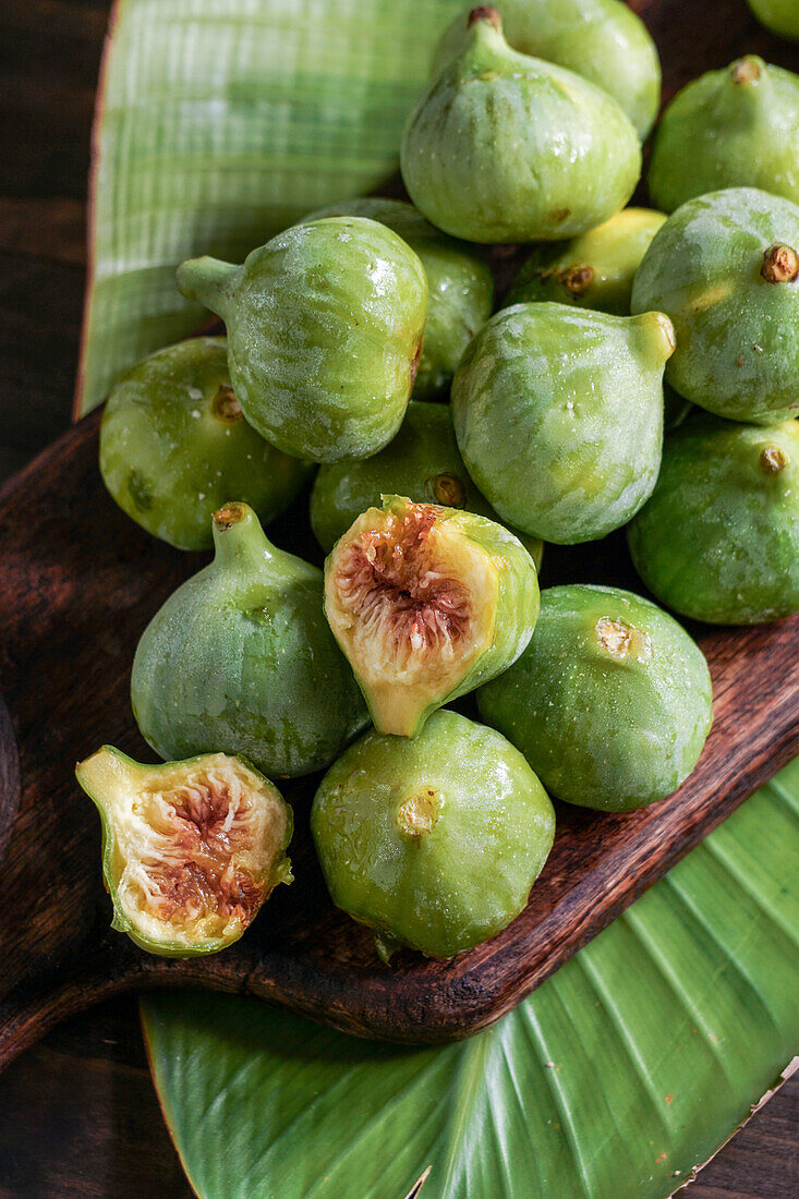 Green ripe figs on a rustic wooden board