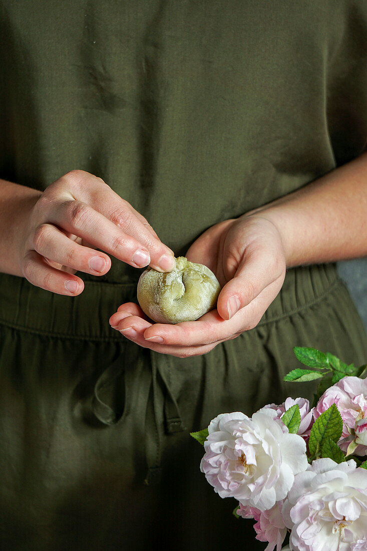 Making mochi (Japanese dessert) with matcha powder and cherries