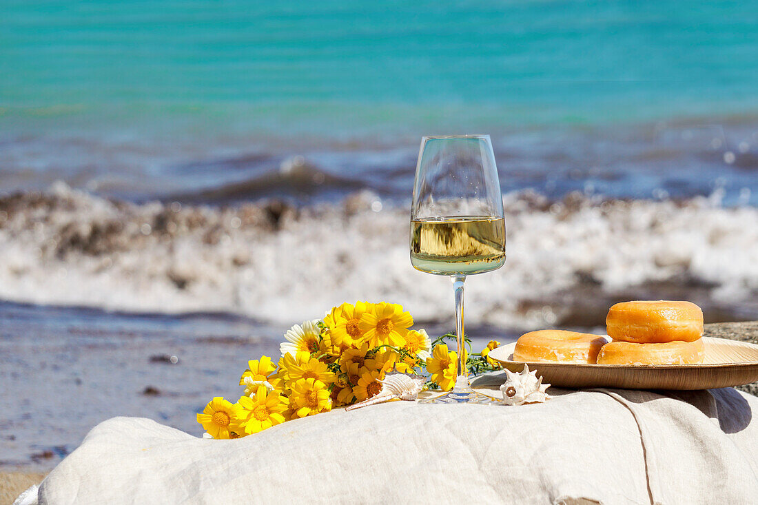Glass of white wine on rock by the sea