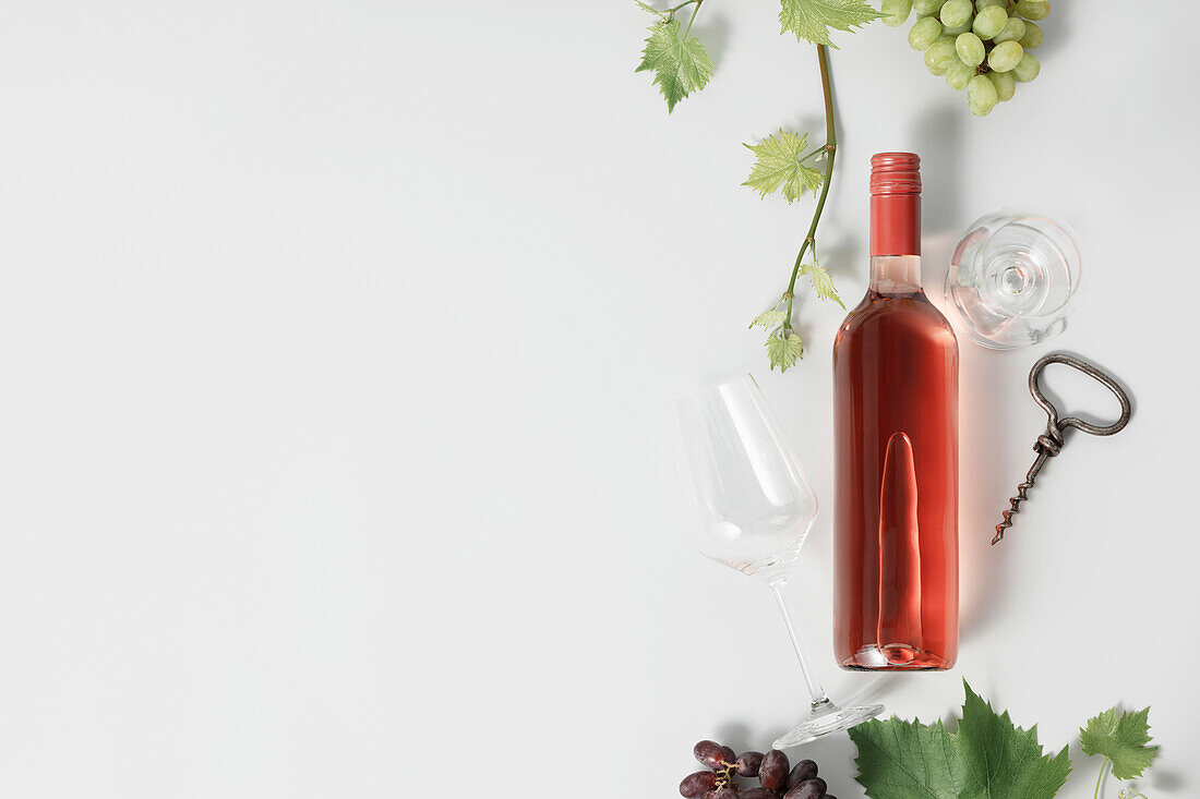Eine Flasche Roséwein und Weintrrauben