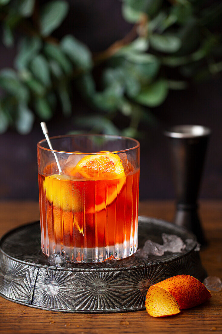 Negroni made with Italian orange bitters, garnished with olives and a slice of orange