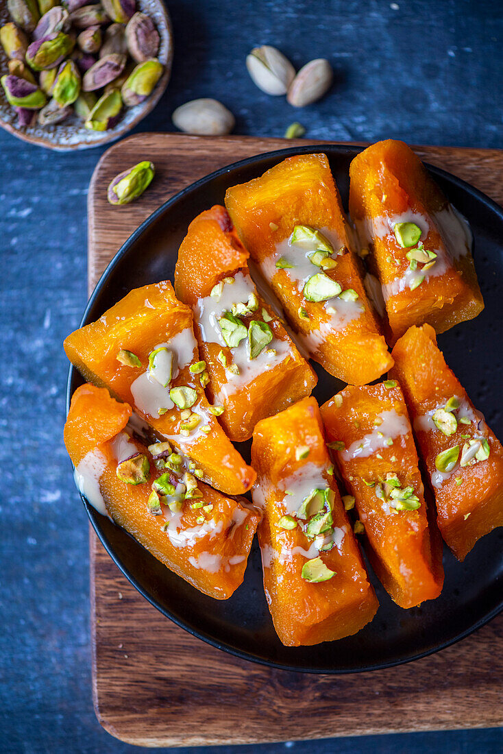 Turkish pumpkin dessert garnished with pistachios and tahini