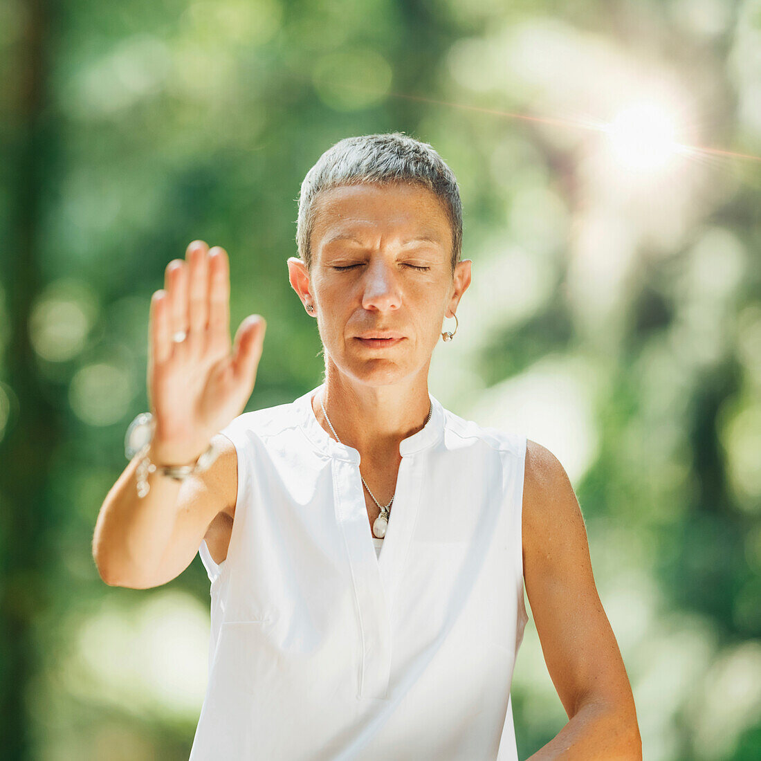 Woman practicing qigong in a forest
