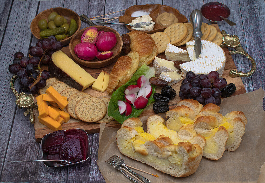 Vegetarian Easter brunch with various breads, eggs, cheese, fruit and cucumbers