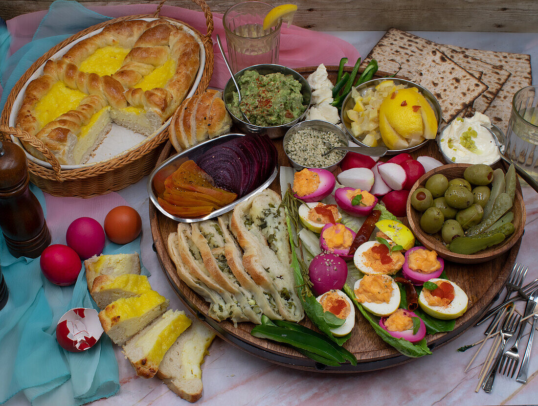 Osterbrunch mit osteuropäischem Pasca-Brot, gefüllten Eiern, Gurken, Aufstrichen und Crudites