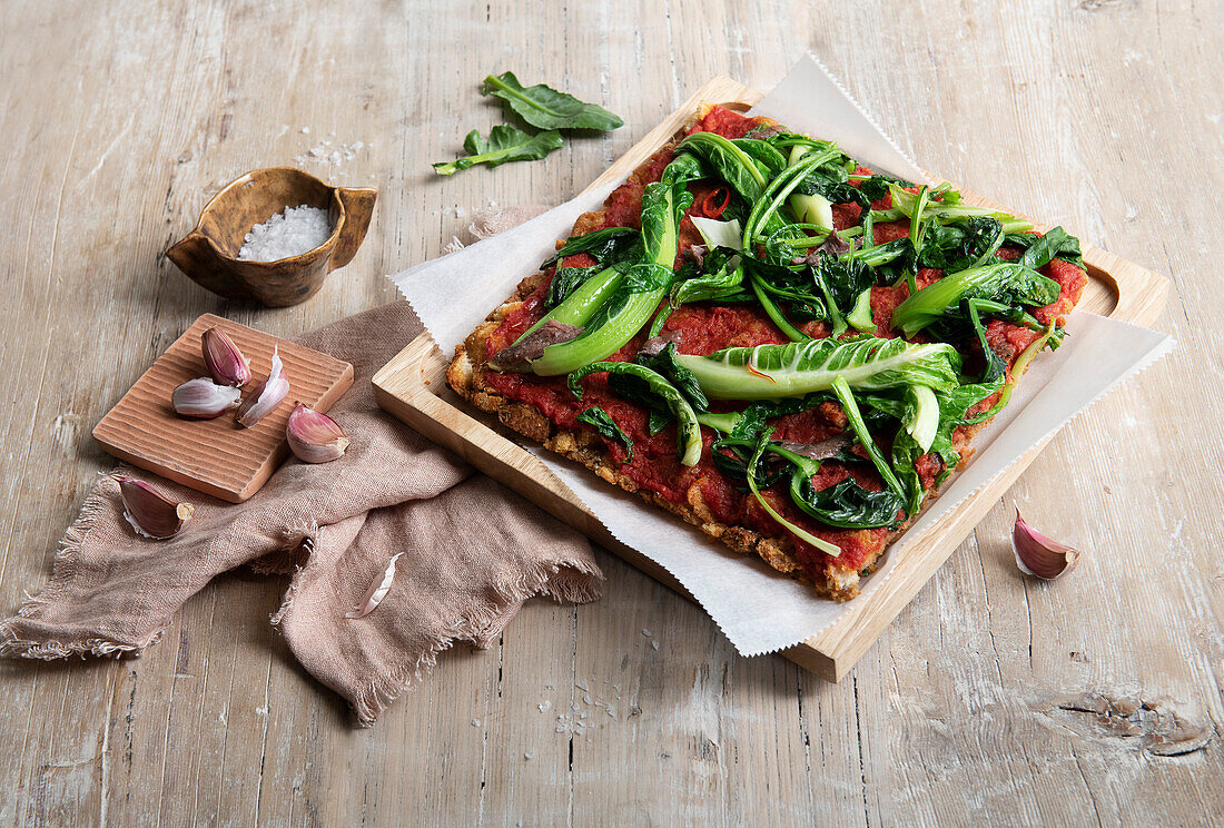 Pizza mit trockenem Brot und Blattgemüse