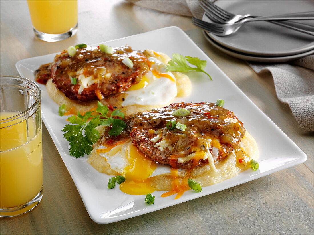 Southwest breakfast with fried eggs, chorizo patties on polenta with chilli sauce and cheese