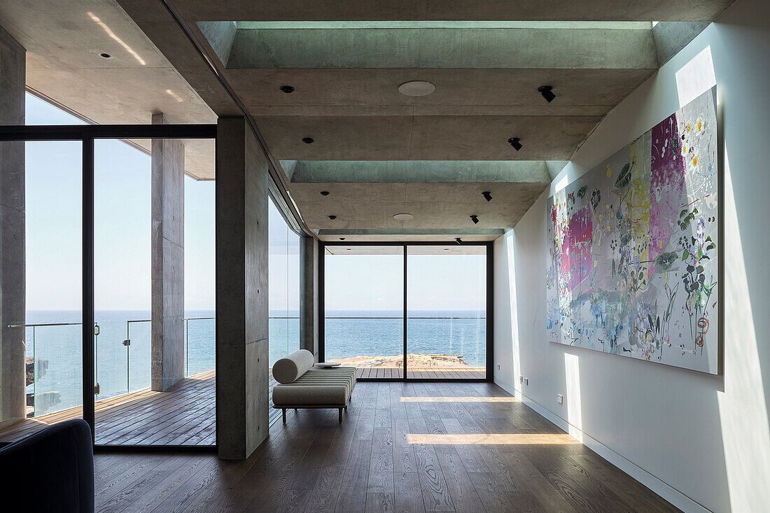 Minimalist living room with sofa and modern artwork on the wall, sea view