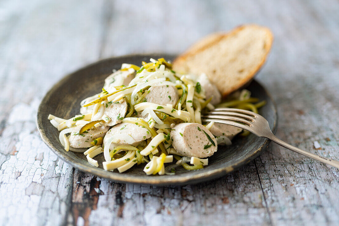 White sausage salad with cheese and gherkins