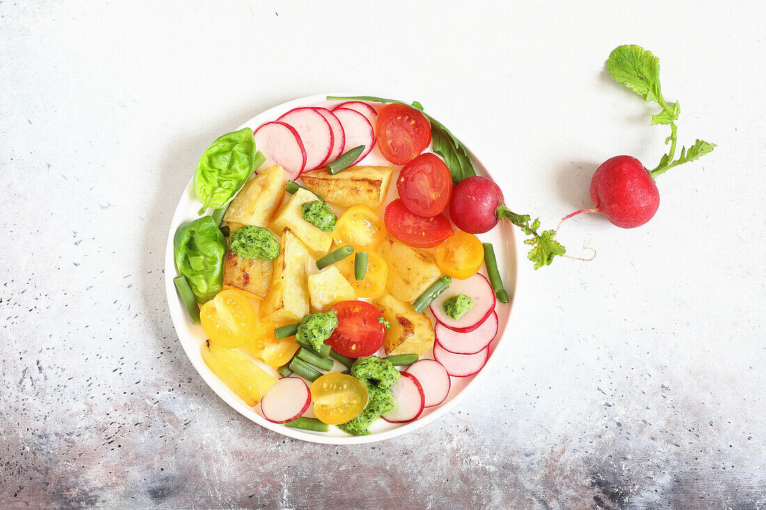 Baked potatoes with tomato, radish and pesto