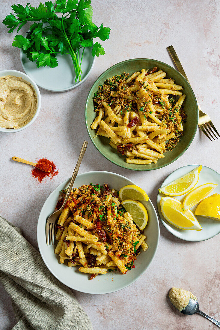 Creamy hummus pasta with crunchy crumbs, dried tomatoes and lemon