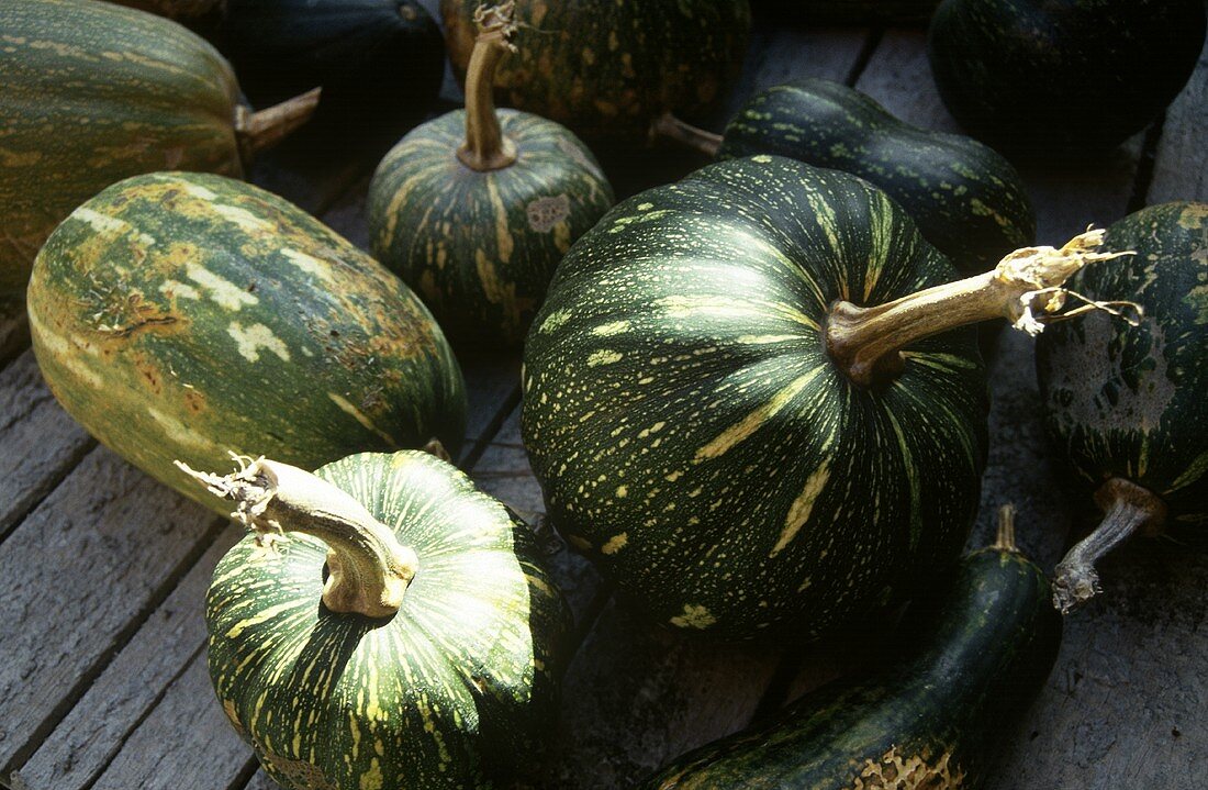 Several pumpkins on a wooden surface