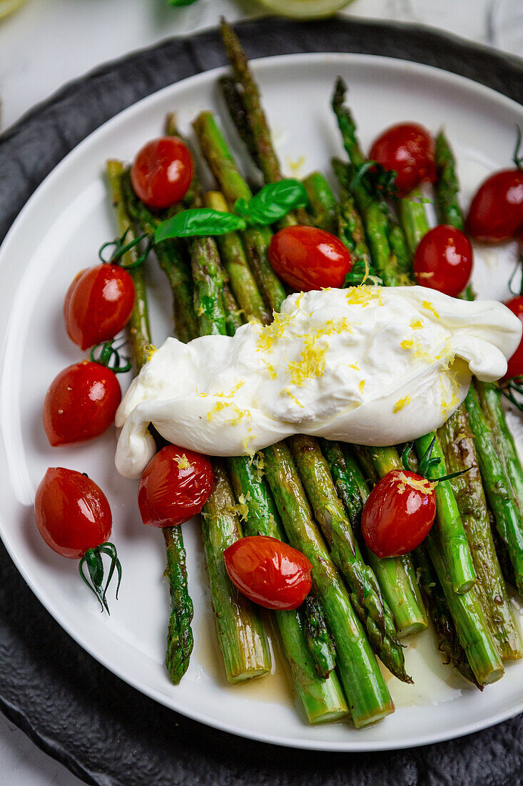 Fried green asparagus with burratini, cherry tomatoes and lemon zest