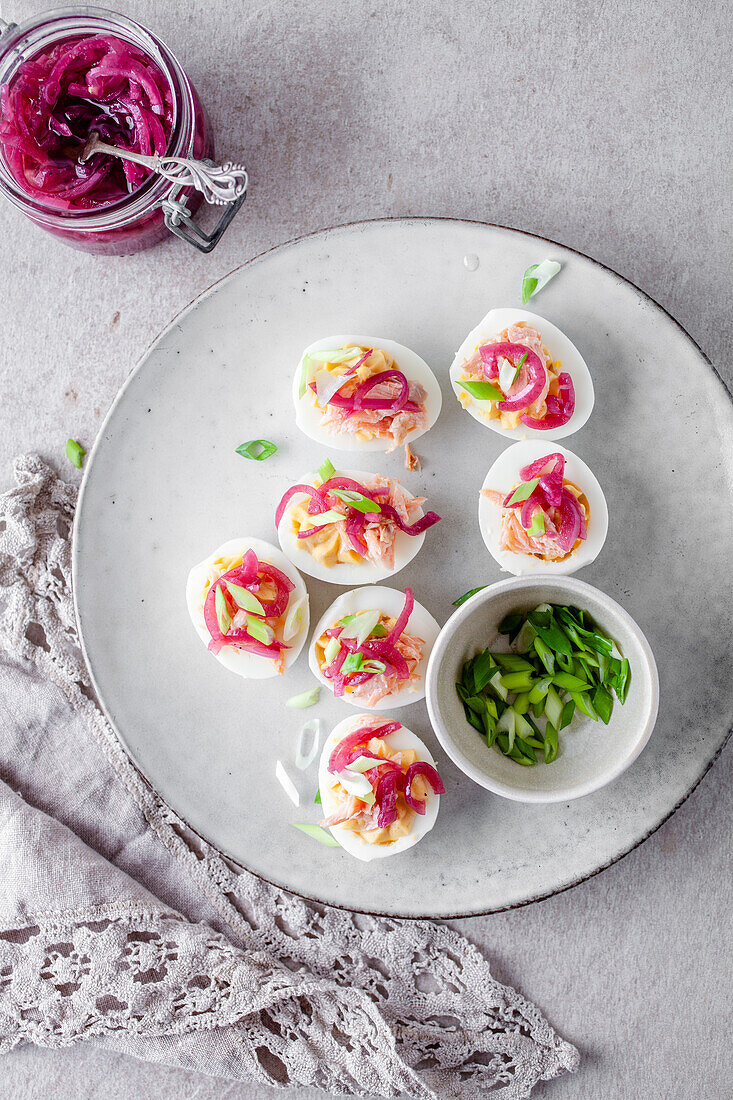 Boiled eggs with smoked salmon, pickled red onions, and green spring onions