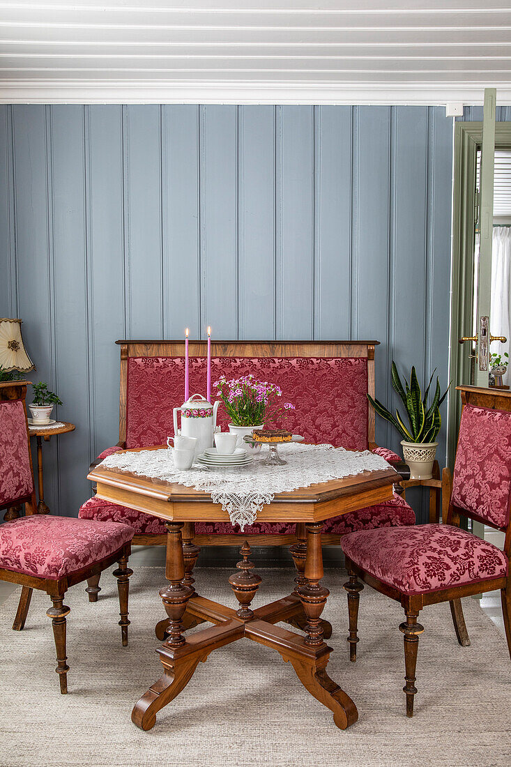 Table set with candles and flowers between antique chairs