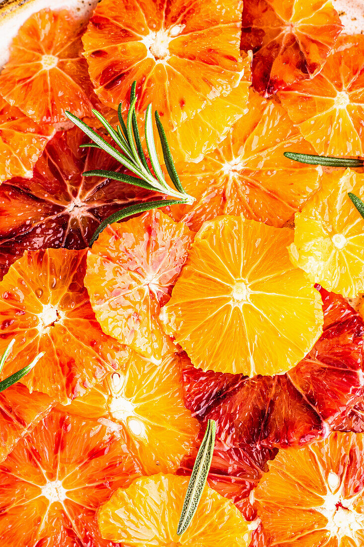 Orangen- und Blutorangenscheiben mit frischem Rosmarin