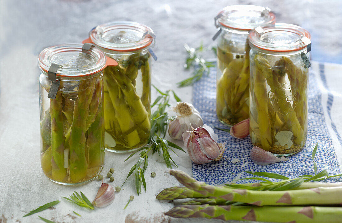 Pickled green asparagus with garlic in jars