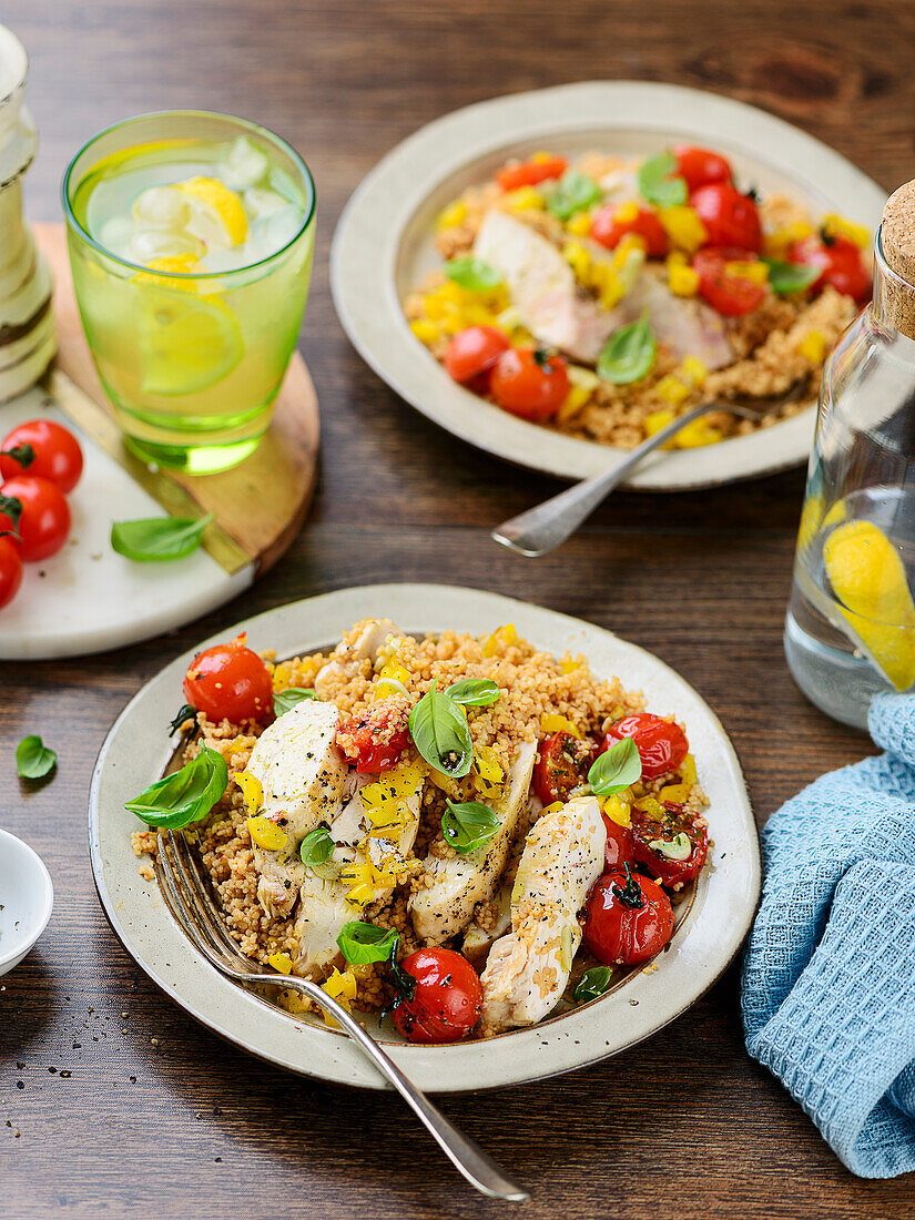 Roasted chicken on couscous with peppers and tomatoes from the oven