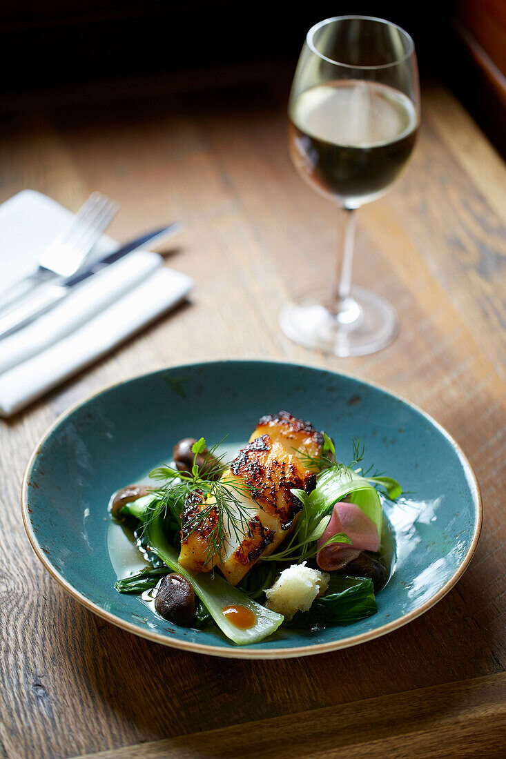 Soy-glazed blackened cod fillet served with pickled kohlrabi, bok choy and shiitake mushrooms