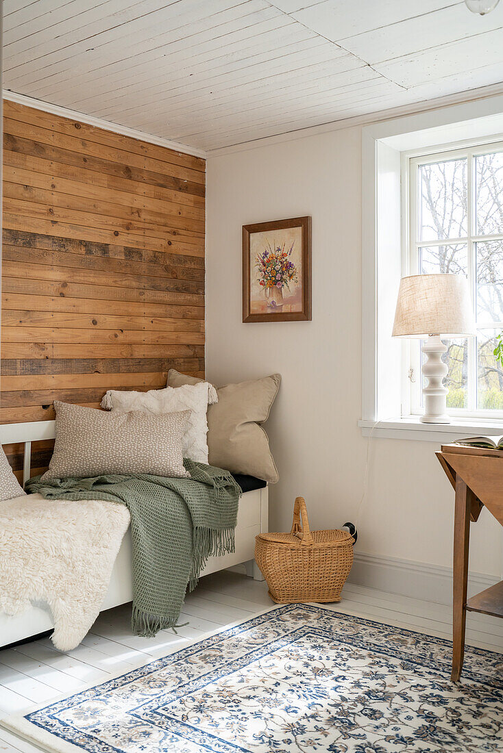 Day bed, woollen blankets, patterned carpet and wood panelling