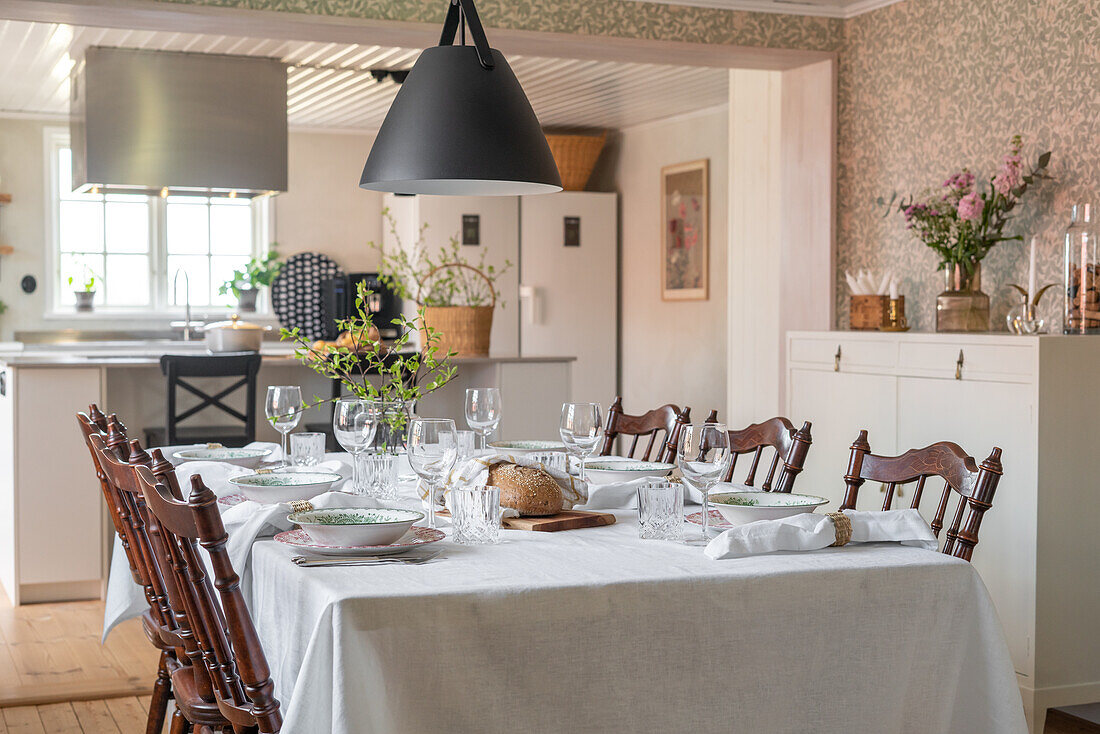 Country-style dining table with decorative branches and pendant light