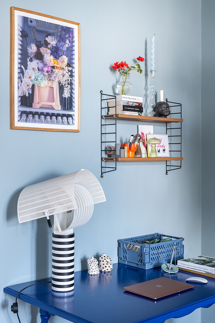 Modern work nook with blue desk and wall shelf