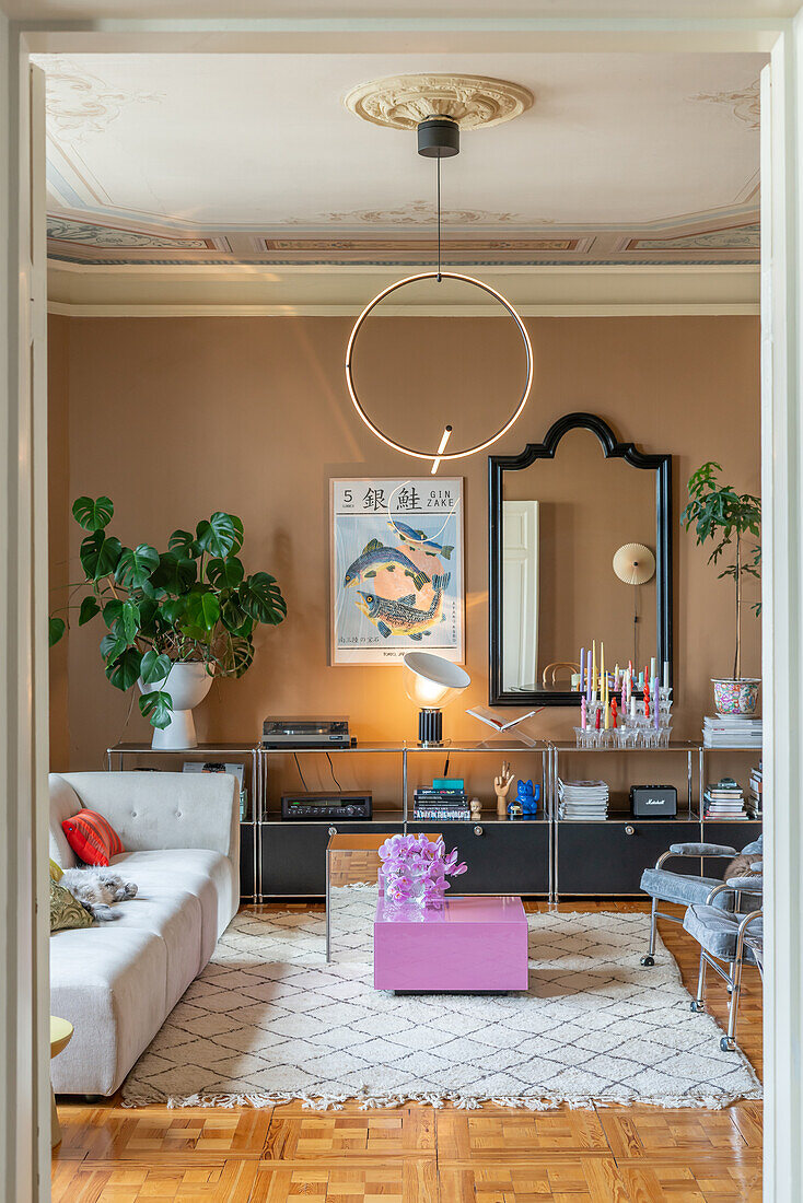 Living room with parquet flooring, mirror, modern pendant light and stucco