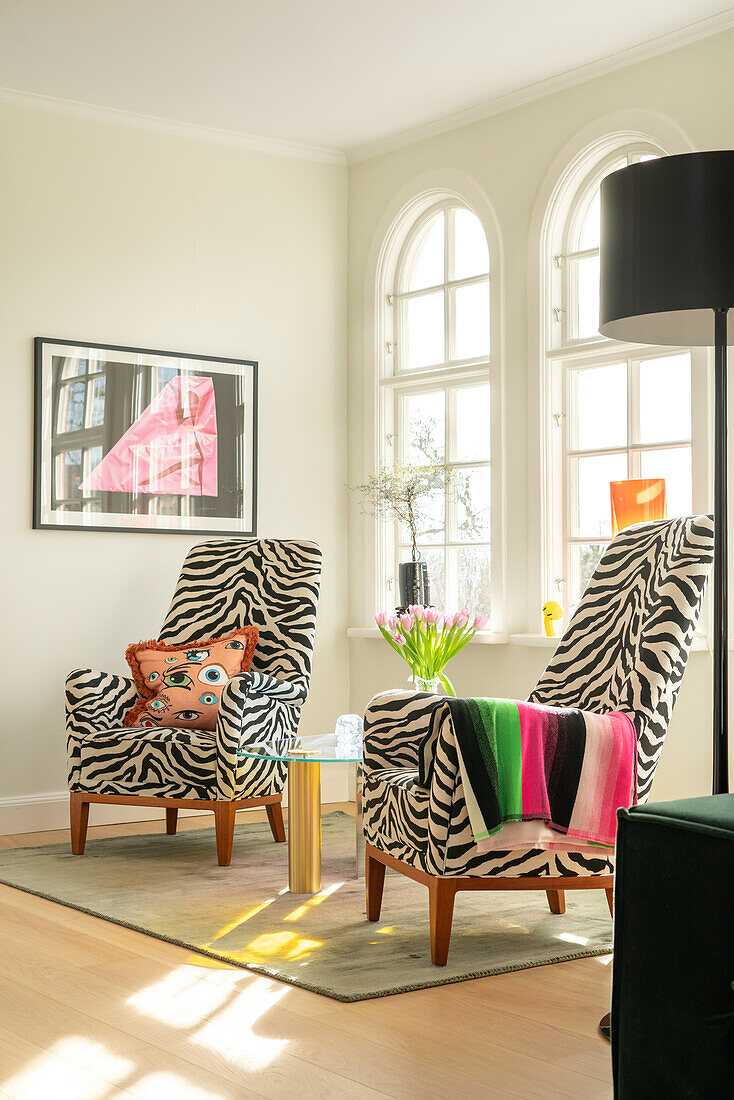 Zwei Sessel mit Zebra-Muster und bunten Akzenten im Wohnzimmer