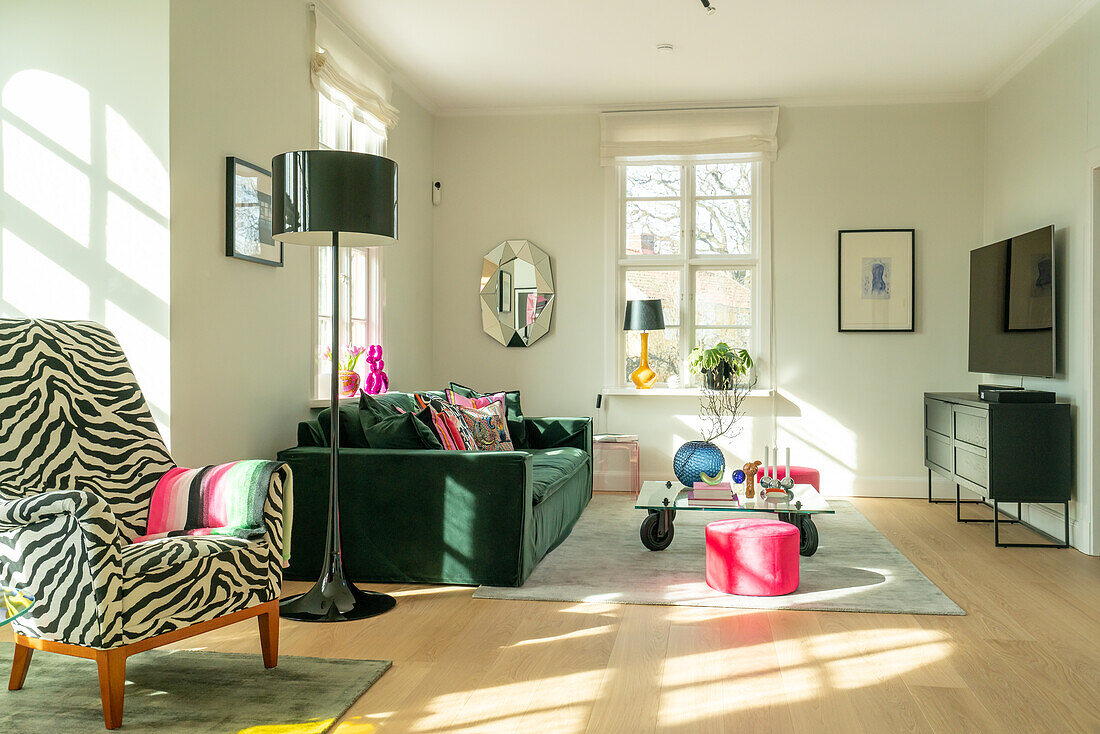 Living room with green velvet sofa and armchair with zebra pattern