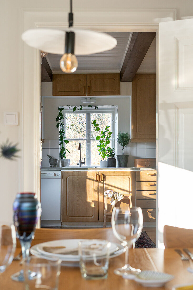 View of a kitchen with wooden elements through an open door from the dining area